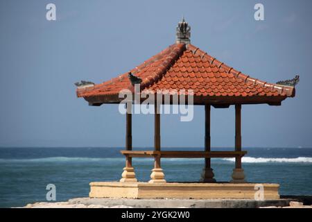 Lever de soleil fantastique sur la plage avec de petits temples. Vue sur la mer jusqu'à l'horizon. Sanur, Bali, Indonésie Banque D'Images