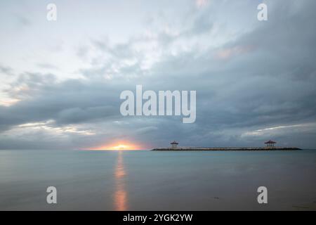 Lever de soleil fantastique sur la plage avec de petits temples. Vue sur la mer jusqu'à l'horizon. Sanur, Bali, Indonésie Banque D'Images