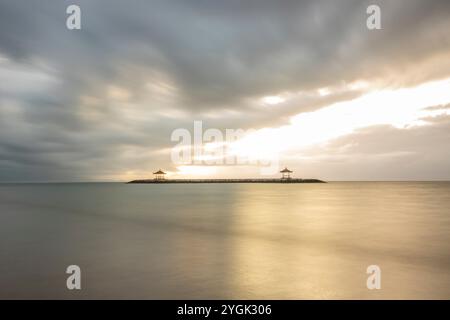 Lever de soleil fantastique sur la plage avec de petits temples. Vue sur la mer jusqu'à l'horizon. Sanur, Bali, Indonésie Banque D'Images