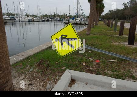 Courbe en S de Seawall sur la droite avec des palmiers verts. Soufflé au-dessus du panneau jaune réfléchissant de rue piétonne Crossing Road, côté droit de la digue. Vue I. Banque D'Images