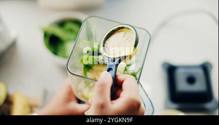 Mains, personne et poudre avec mélangeur dans la cuisine avec des ingrédients biologiques, préparer smoothie et boisson nutritive. Fille, légumes et machine pour Banque D'Images