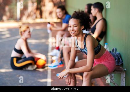 Basket-ball, sourire et penser avec la femme sur le banc à la cour pour la pause, le fitness ou le sport en plein air. Avenir, idée et vision avec un athlète africain heureux Banque D'Images