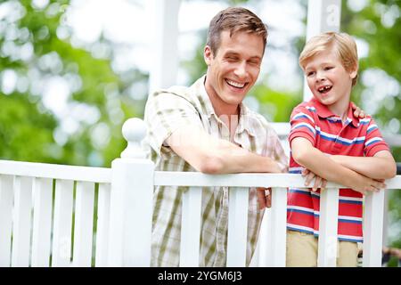 Maison, garçon et rire avec le père sur le balcon pour le soutien, les liens et les soins au Canada. Les gens, les parents et heureux avec l'enfant comme la famille sur la rupture avec l'amour Banque D'Images