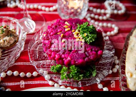 Table de fête avec salade Rosolli - repas de Noël finlandais traditionnel à base de betteraves cuites. Délices de célébration Banque D'Images