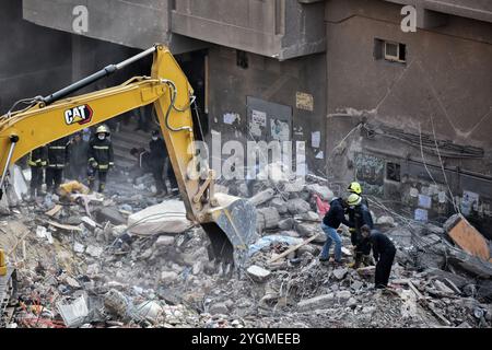 Le Caire, Égypte. 27 mars 2021. Les pompiers recherchent des survivants sur le site où un bâtiment de huit étages s'est effondré pendant la nuit dans le quartier de Gesr al-Suez au Caire. L'effondrement du bâtiment a tué au moins 18 personnes et blessé deux douzaines Banque D'Images