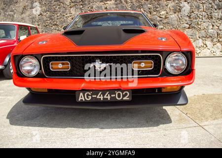 Puissante ford Mustang Mach 1 rouge garée, montrant son impressionnante calandre et son emblème de cheval Banque D'Images