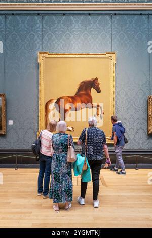 Londres, Royaume-Uni - 8 mai 2024 : les touristes voient la peinture George Stubbs du cheval, Whistlejacket, peinte en 1772, à la National Gallery de Londres. Stubb Banque D'Images