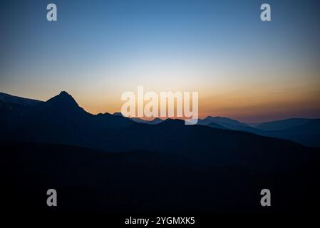 Le coucher de soleil au sommet du mont Kopieniec à Zakopane, en Pologne, jette une lumière chaude sur les montagnes des Tatras, créant un paysage magnifique qui captive la nature Banque D'Images