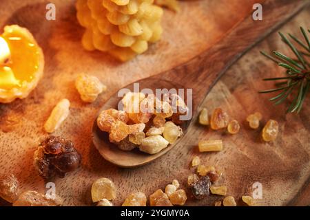 Résine d'encens sur une cuillère avec des bougies de cire d'abeille et des branches d'épicéa à Noël Banque D'Images