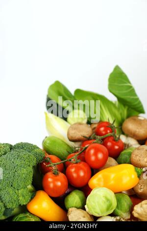 Légumes biologiques mélangés sur un fond blanc. Tomates, brocoli, champignons, PAC Choi, chou de Chine, concombres, poivrons, choux de Bruxelles, gingembre, Banque D'Images