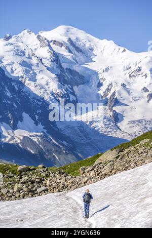 Alpiniste traversant un champ de neige, vue sur les spectaculaires sommets glaciaires du Mont Blanc, massif du Mont Blanc, aiguilles rouges, Chamonix-Mont-Blanc, haute-S. Banque D'Images