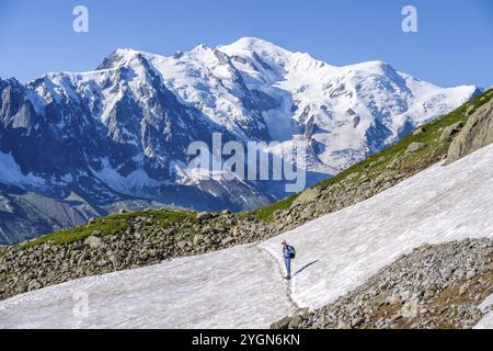 Alpiniste traversant un champ de neige, vue sur les spectaculaires sommets glaciaires du Mont Blanc, massif du Mont Blanc, aiguilles rouges, Chamonix-Mont-Blanc, haute-S. Banque D'Images