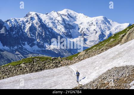 Alpiniste traversant un champ de neige, vue sur les spectaculaires sommets glaciaires du Mont Blanc, massif du Mont Blanc, aiguilles rouges, Chamonix-Mont-Blanc, haute-S. Banque D'Images