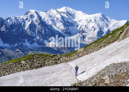 Alpiniste traversant un champ de neige, vue sur les spectaculaires sommets glaciaires du Mont Blanc, massif du Mont Blanc, aiguilles rouges, Chamonix-Mont-Blanc, haute-S. Banque D'Images