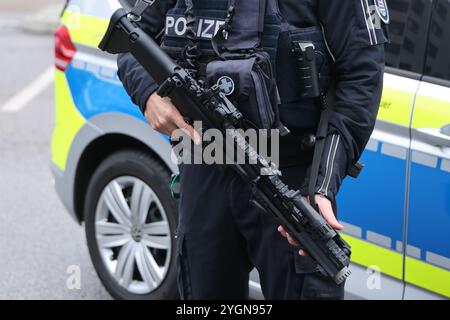 Erfurt, Allemagne. 08 novembre 2024. Le commissaire de police Alexander Albinus se tient en équipement de protection avec le nouveau fusil à moyenne portée de la police de Thuringe devant un véhicule d'urgence lors d'une conférence de presse du Bureau d'État des enquêtes criminelles. Plus de 1000 fusils du fabricant belge FN Herstal ont été nouvellement achetés. Les armes à moyenne portée sont utilisées par la police lorsqu'il s'agit de frapper des cibles éloignées. Crédit : Bodo Schackow/dpa/Alamy Live News Banque D'Images