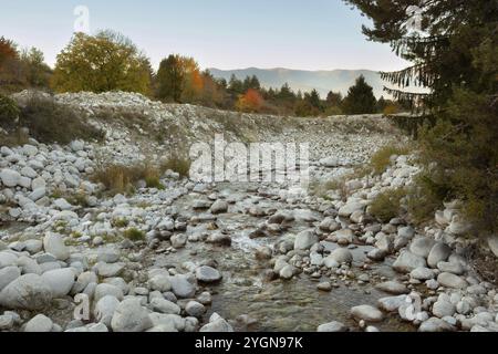 Bansko, Bulgarie paysage d'automne avec la rivière Glazne, arbres colorés, coucher de soleil Rila montagnes pics Banque D'Images