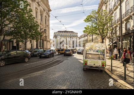 Scène de rue animée avec tram, voitures et piétons sur une journée ensoleillée, occupé Praca Luis de Camoes avec tram à Lisbonne, Portugal, Europe Banque D'Images