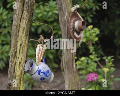 Décoration de jardin sur une clôture en bois avec des tasses en céramique suspendues et des plantes, Borken, Muensterland, Allemagne, Europe Banque D'Images