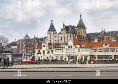 Amsterdam, pays-Bas, 2 avril 2016 : gare ferroviaire et maisons anciennes traditionnelles, gens à Amsterdam, pays-Bas Banque D'Images