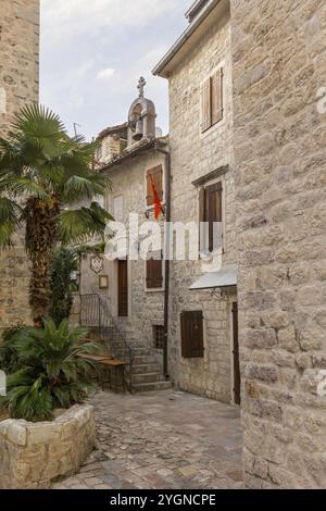 Kotor, Monténégro, 20 septembre 2023 : coucher de soleil rue vide de la vieille ville avec ancienne église en pierre, Europe Banque D'Images