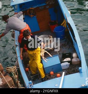 Harte Arbeit auf einem Fischerboot vor den Kanalinseln, um 1985. Banque D'Images
