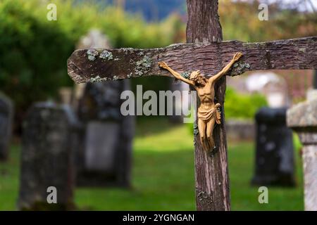 Beau Jésus-Christ sur le crucifix avec des arbres en arrière-plan, cimetière sur une journée ensoleillée, nouvelle vie et concept de religion Banque D'Images