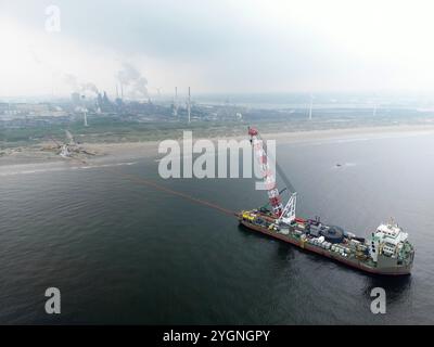 Un navire déploie un navire d'un parc éolien offshore à un hub électrique terrestre à Wijk aan Zee, aux pays-Bas. Les parcs éoliens sont par câbles ou tuyaux vers la zone côtière Banque D'Images