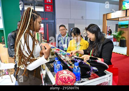 Shanghai. 7 novembre 2024. Les visiteurs regardent les expositions au Pavillon Togo lors de la septième exposition internationale d'importation de Chine (CIIE) à Shanghai, dans l'est de la Chine, le 7 novembre 2024. L'édition actuelle de CIIE a élargi l'échelle de l'exposition pour les pays et les marques africains à la zone d'exposition du pays et à la zone des produits alimentaires et agricoles, où une large gamme de produits africains de haute qualité avec des caractéristiques distinctives sont présentés. Crédit : Zhang Cheng/Xinhua/Alamy Live News Banque D'Images