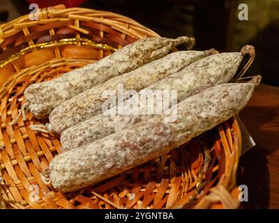 Gros plan sur des saucisses salées reposant sur un panier en osier, présentant la charcuterie française traditionnelle Banque D'Images