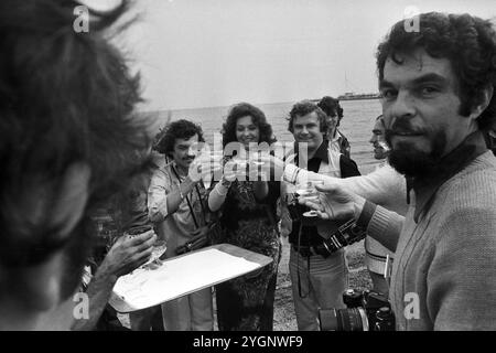 Die rumänische Pop-Sängerin Angela Similea stößt an mit Pressefotografen am Strand von Sopot, WO sie beim Intervision Song Contest 1977 (Sopot 77) zusammen mit Olimpia Panciu und Marius Teicu [Ţeicu] auf den 9. Platz und mit ihrem Solo-Auftritt auf den 18. Platz kam. Rechts neben Mir steht der DDR-Fotograf Tassilo Leher, Polen 1977. Banque D'Images