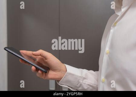 Femme utilisant le téléphone intelligent mobile dans la chambre d'hôtel. Gros plan sur le smartphone de la main féminine. Banque D'Images