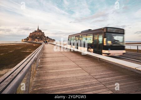 Mont Saint-Michel, France - 25 février 2024 : Mont Saint-Michel et navette avec des touristes photographiés en hiver depuis le long pont en Normandie Banque D'Images