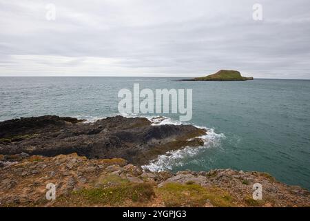 Vue sur la baie de Rhossili sur la petite île de Worm's Head sur la côte galloise. Banque D'Images