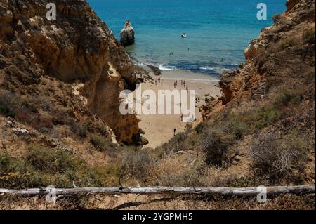 Oasis de plage cachée encadrée par des falaises escarpées à Lagos, avec des baigneurs profitant d'un paradis isolé Banque D'Images