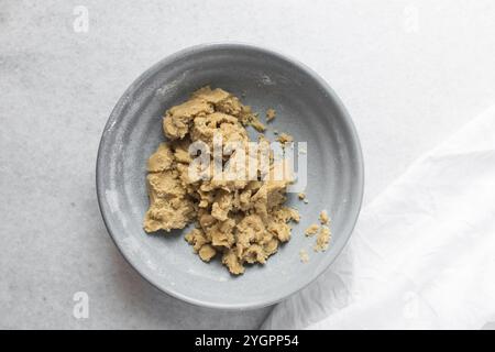 Vue de dessus de la pâte à gâteau de lune mélangée, vue de dessus de la pâte à gâteau de lune maison dans un bol gris, processus de fabrication des gâteaux de lune pour le festival de mi-automne Banque D'Images