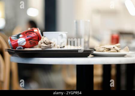 Viladecans. Espagne - 08 novembre 2024 : L'intérieur d'un café moderne avec des tables et des chaises vides, capturant le calme après les clients h. Banque D'Images