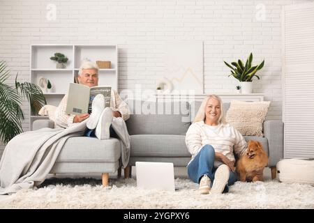 Heureux couple aîné avec chien pomeranian mignon à la maison Banque D'Images