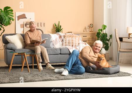 Heureux couple aîné avec chien pomeranian mignon à la maison Banque D'Images