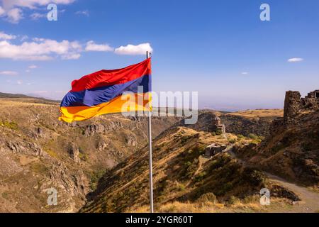 Vue aérienne de drone au drapeau de l'Arménie et célèbre église Vahramashen du 11ème siècle, près de la forteresse d'Amberd dans la journée ensoleillée d'été. Falaise avec Arkashian Banque D'Images