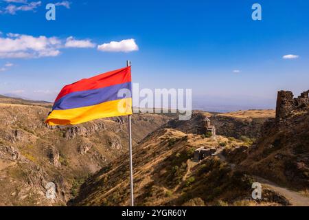 Vue aérienne de drone au drapeau de l'Arménie et célèbre église Vahramashen du 11ème siècle, près de la forteresse d'Amberd dans la journée ensoleillée d'été. Falaise avec Arkashian Banque D'Images