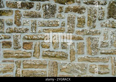 Mur de pierre texturé présentant un mélange de matériaux dans un cadre rustique. Fond parfait Banque D'Images