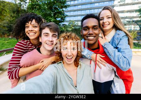 Heureux groupe de jeunes étudiants s'amusant à prendre selfie à l'extérieur Banque D'Images