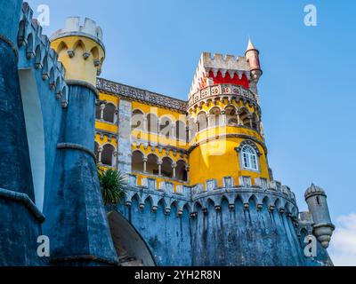 Vue impressionnante sur le célèbre Palais de Pena avec la cour des arches jaunes et la chapelle rouge avec sa tour de l'horloge, Sintra, Portugal Banque D'Images