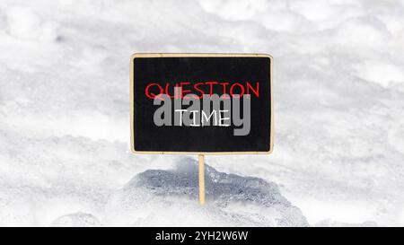 Symbole heure des questions. Mots conceptuels heure des questions sur le beau tableau noir de craie jaune. Beau fond de neige blanc. Heure des affaires et des questions co Banque D'Images