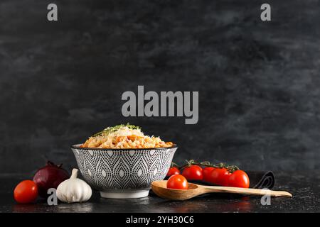 Bol de pâtes fagioli avec fromage et ingrédients sur fond noir Banque D'Images