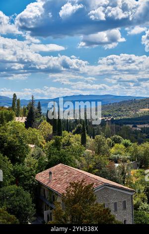 Paysage pittoresque avec des arbres, des collines et des nuages sous un ciel bleu en Provence, Sud de la France. Banque D'Images