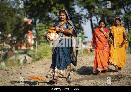 Les dévots hindous exécutent des rituels alors qu'ils offrent des prières au Dieu Soleil dans la rive de la rivière Brahmapoutre à l'occasion du festival 'Chhath Puja' Banque D'Images