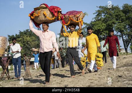 Les dévots hindous exécutent des rituels alors qu'ils offrent des prières au Dieu Soleil dans la rive de la rivière Brahmapoutre à l'occasion du festival 'Chhath Puja' Banque D'Images