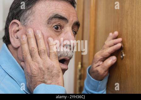 Man looking through judas Banque D'Images