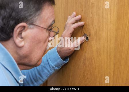 Man looking through judas Banque D'Images